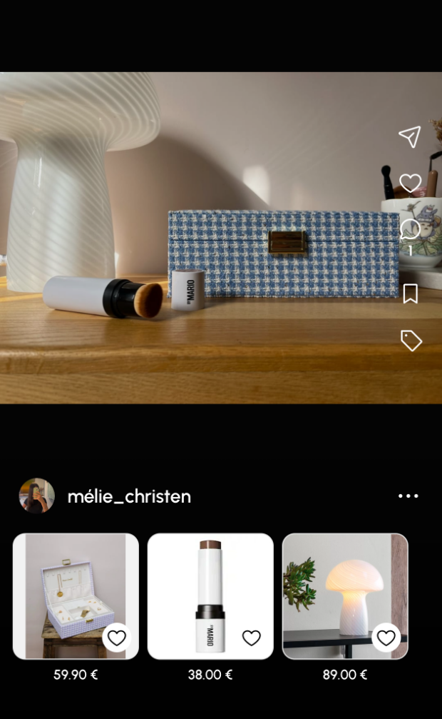 Une publication joezz de mélie_christen : sur une console en bois, une enceinte habillée de tissu bleu, un stick de maquillage et une lampe. Trois produits sont identifiés sous la photo — une boîte à bijoux à 59,90 €, le stick à 38,00 € et une lampe champignon à 89,00 €.